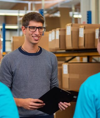 Produktionsmitarbeiter bei einer Besprechung im Lager