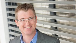 Person mit Brille vor Raffstore