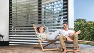 Paar genießt Tageslicht am Liegestuhl auf Terasse