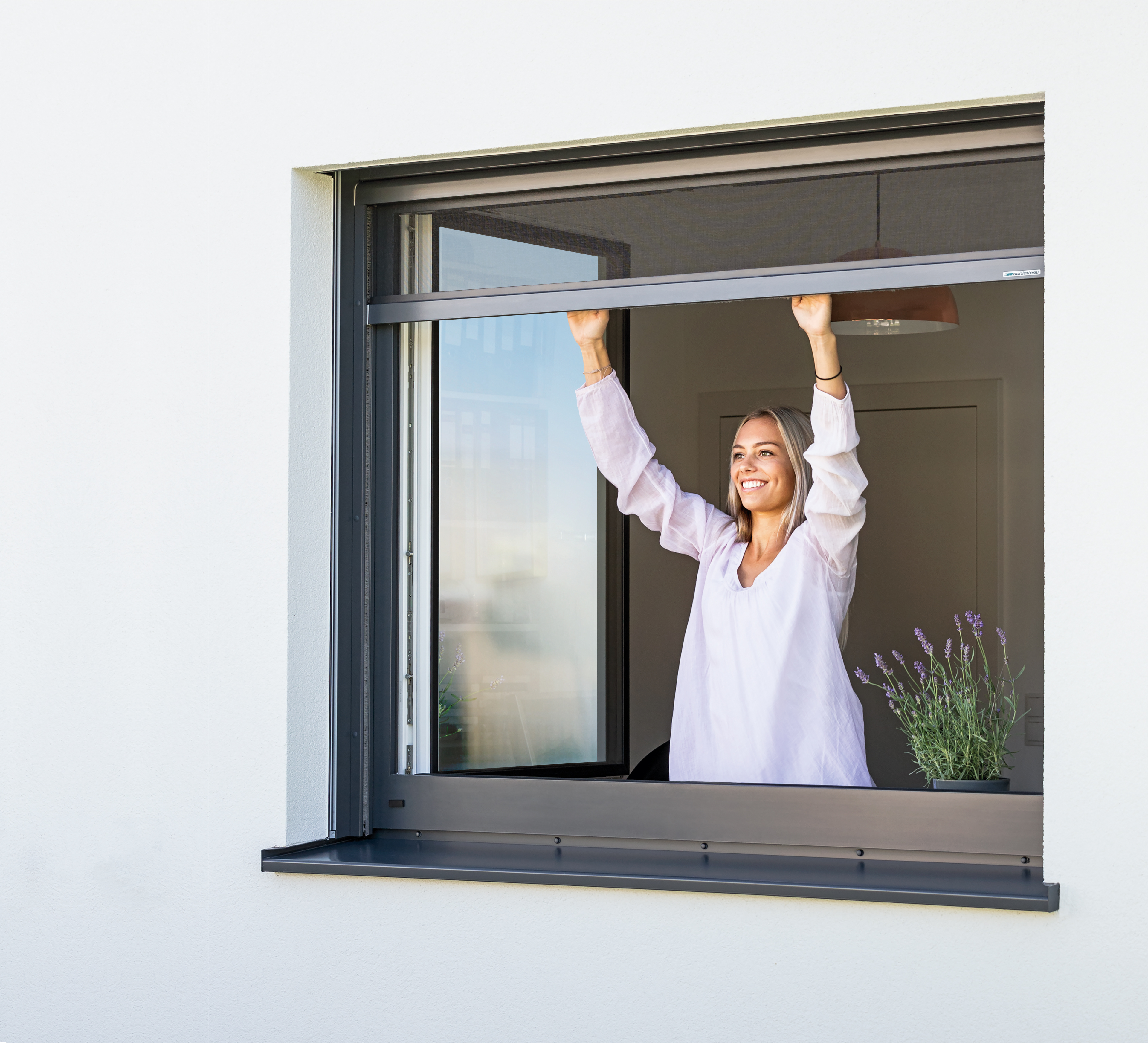 Frau bedienst Insektenschutz Rollo bei Fenster