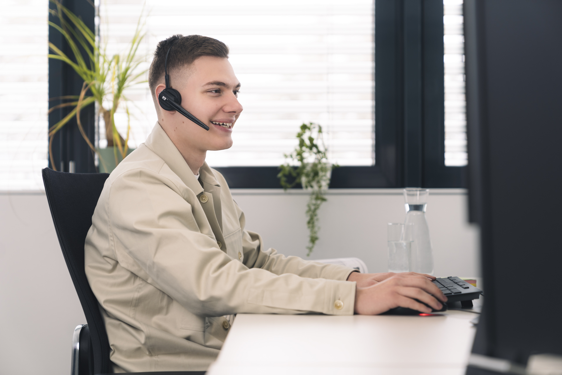 Person sitzt vor PC im Büro